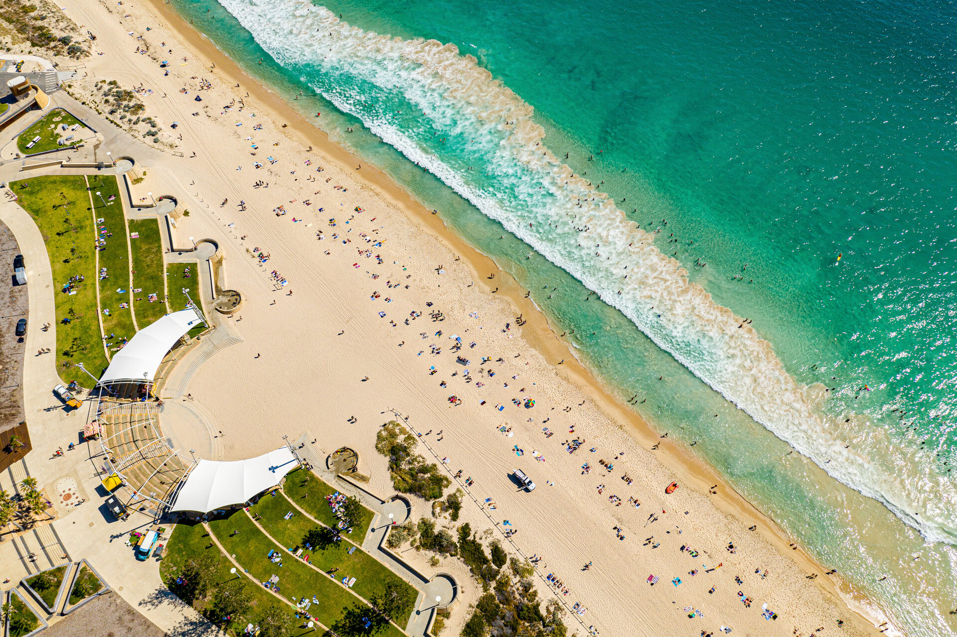 Aerial view of Scarborough beach foreshore with turquoise surf and the grassed amphitheatre
